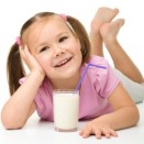Cute little girl with a glass of milk, isolated over white